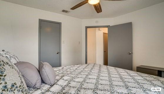 562 Stringfellow Drive Coppell, TX 75019 - Photo 16 of 24 Bedroom featuring white walls, a ceiling fan with wood-finish blades, and two gray interior doors