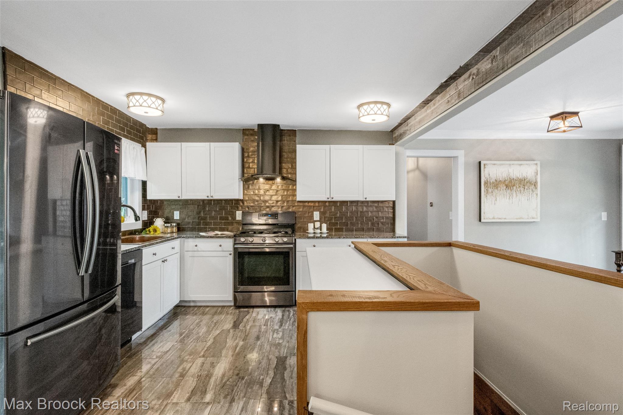 2905 Lahser Road Bloomfield Hills, MI 48304 - Photo 12 of 28 Bright kitchen featuring white cabinetry, stainless steel appliances, a dark tile backsplash, and wood-finish flooring