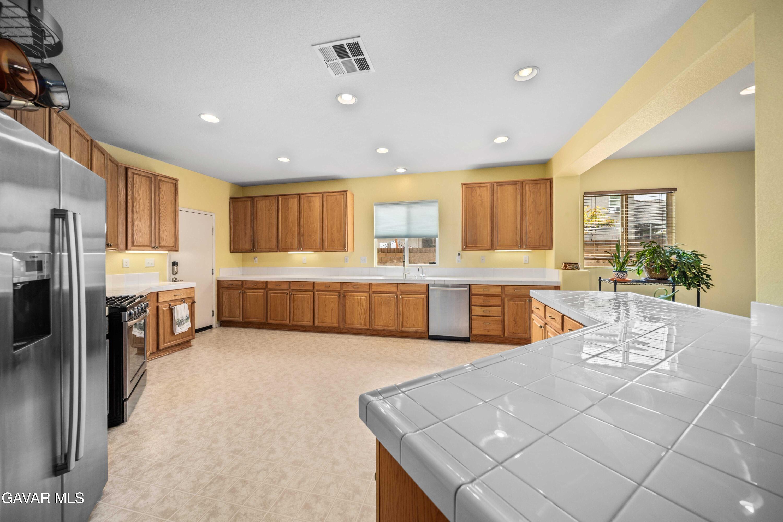 43219 Fanchon Avenue Lancaster, CA 93536 - Photo 11 of 51 a large kitchen with a large counter top stainless steel appliances and cabinets