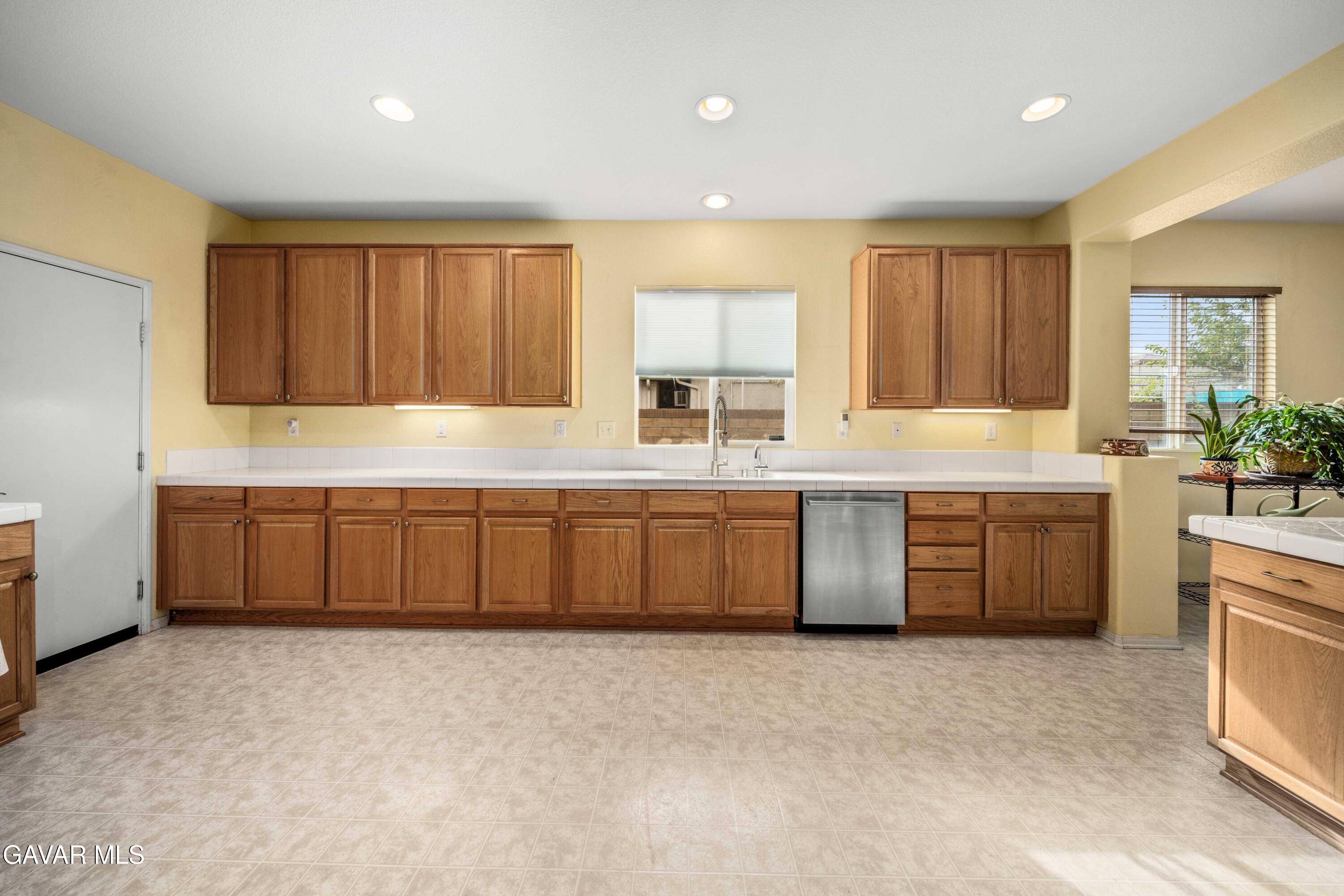 43219 Fanchon Avenue Lancaster, CA 93536 - Photo 12 of 51 a kitchen with stainless steel appliances a sink a stove a refrigerator cabinets and a window