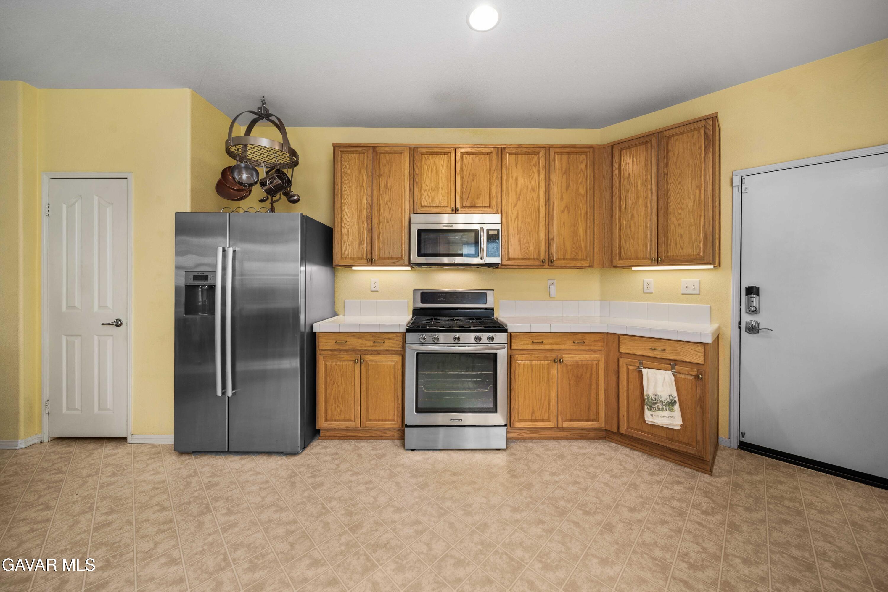 43219 Fanchon Avenue Lancaster, CA 93536 - Photo 13 of 51 a kitchen with granite countertop a refrigerator stove and oven