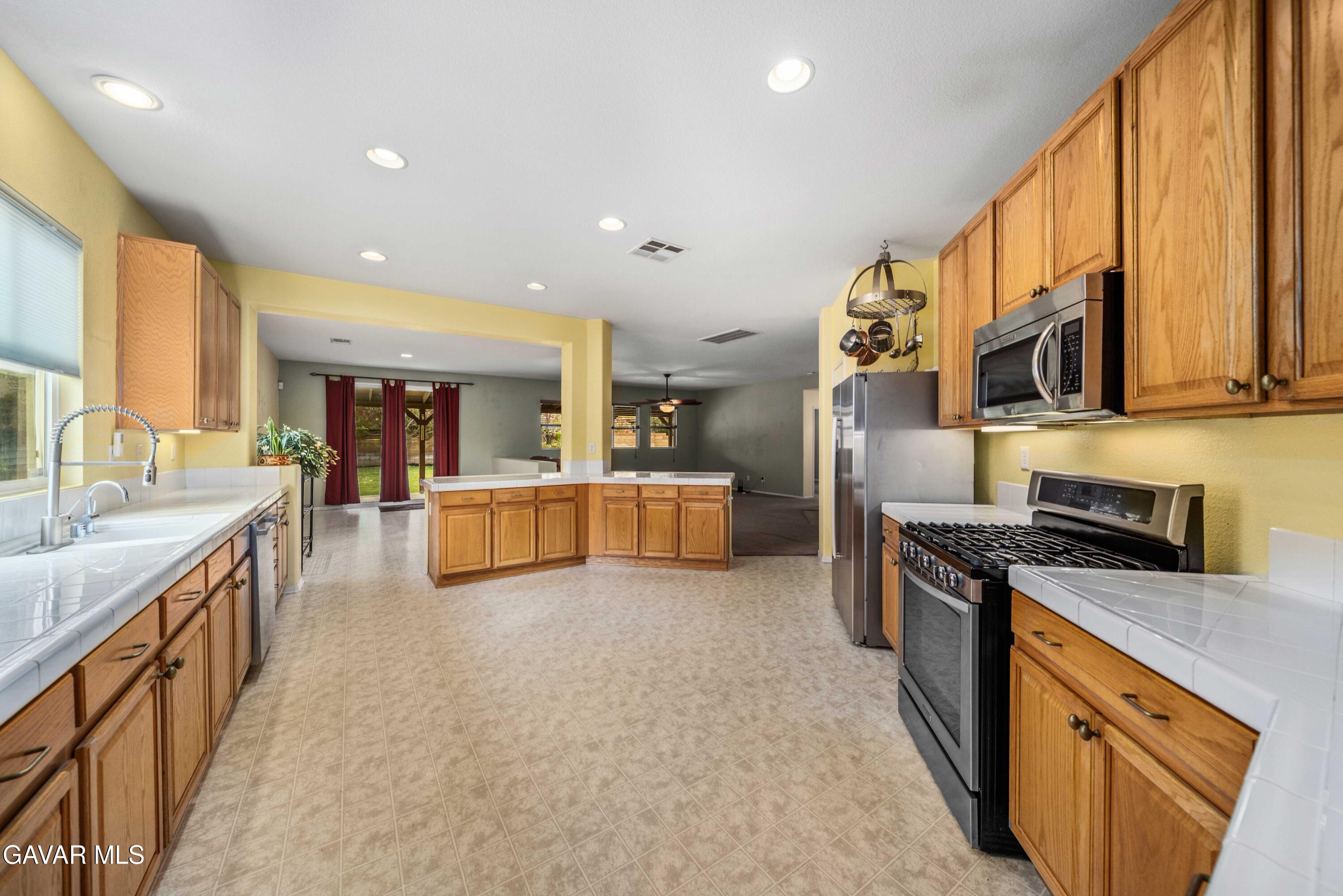 43219 Fanchon Avenue Lancaster, CA 93536 - Photo 16 of 51 a kitchen with stainless steel appliances granite countertop a stove a sink and a refrigerator