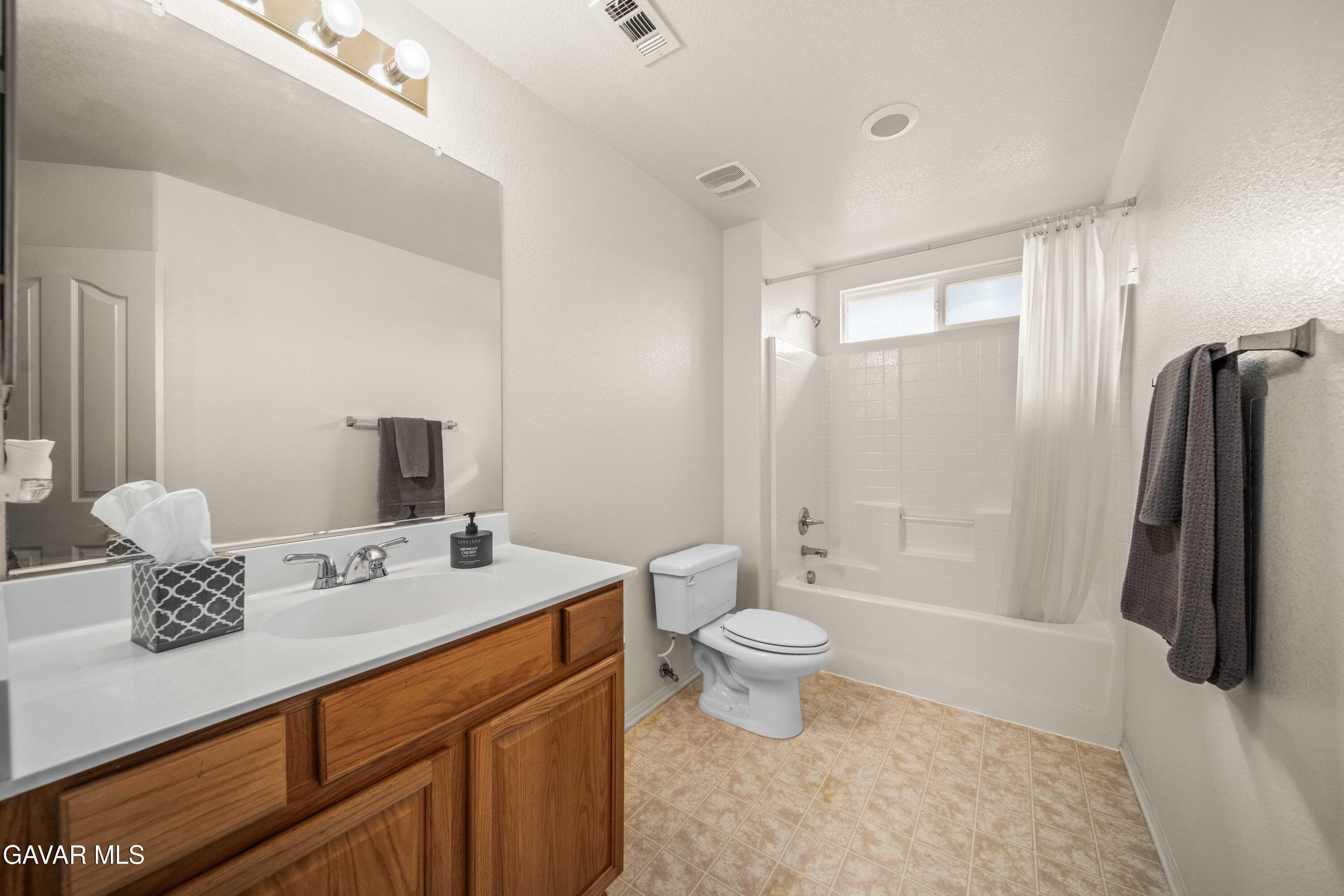 43219 Fanchon Avenue Lancaster, CA 93536 - Photo 35 of 51 a bathroom with a sink a toilet a mirror and shower