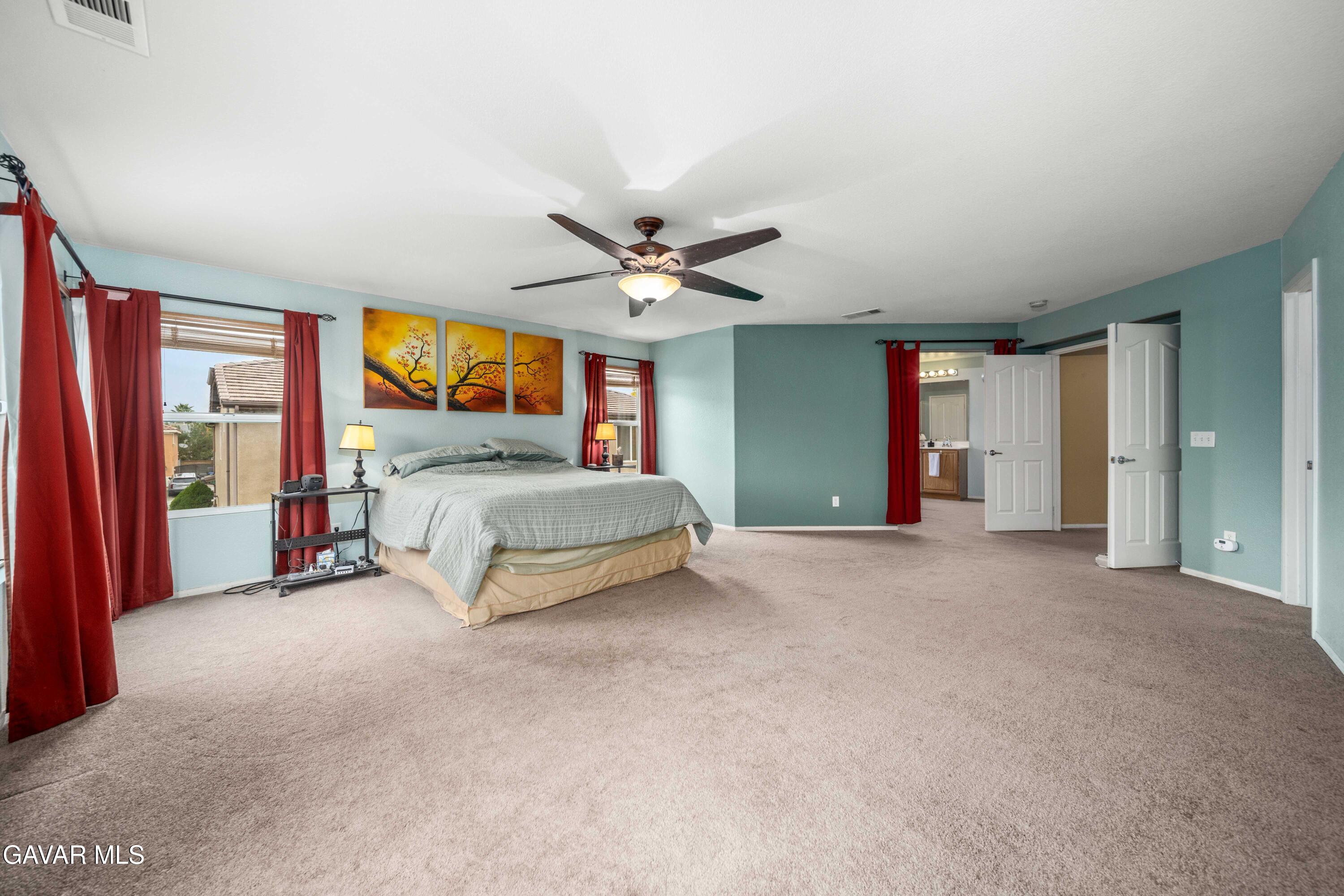 43219 Fanchon Avenue Lancaster, CA 93536 - Photo 41 of 51 a spacious bedroom with a bed and a ceiling fan
