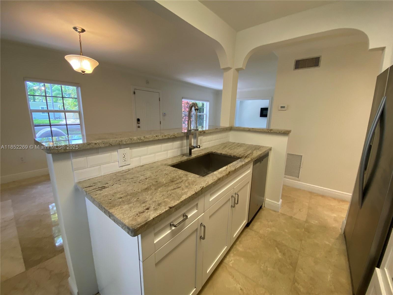 5940 Southwest 47th Street Miami, FL 33155 - Photo 6 of 15 a kitchen with granite countertop a sink stove and cabinets