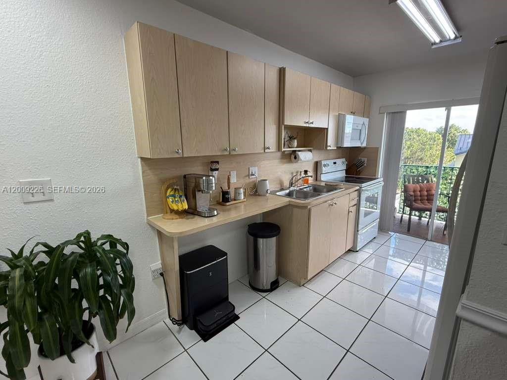 3514 West 76th Street, Unit 203 Hialeah, FL 33018 - Photo 14 of 39 a kitchen with a sink cabinets and window