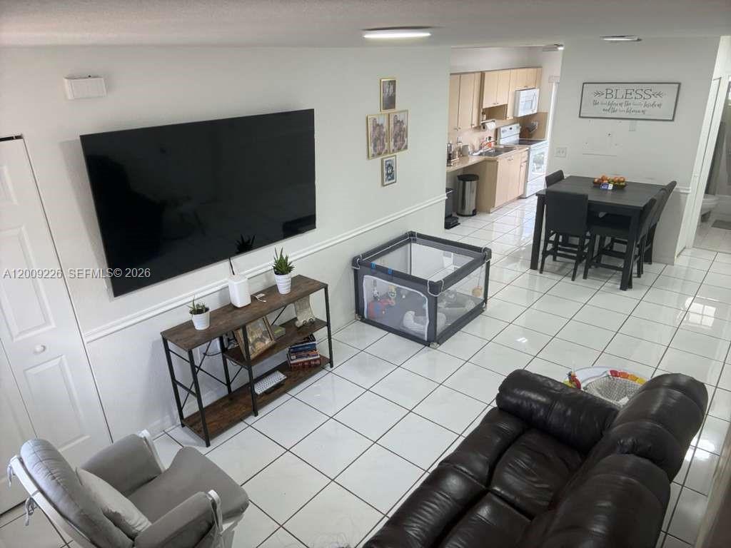 3514 West 76th Street, Unit 203 Hialeah, FL 33018 - Photo 4 of 39 a living room with furniture and a flat screen tv