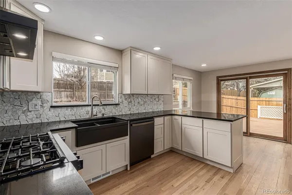 a kitchen with granite countertop a sink a counter space appliances and cabinets