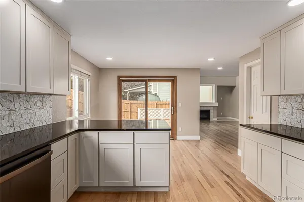 a view of a kitchen with wooden floor and electronic appliances