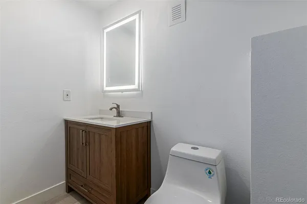 a bathroom with a sink a toilet and mirror