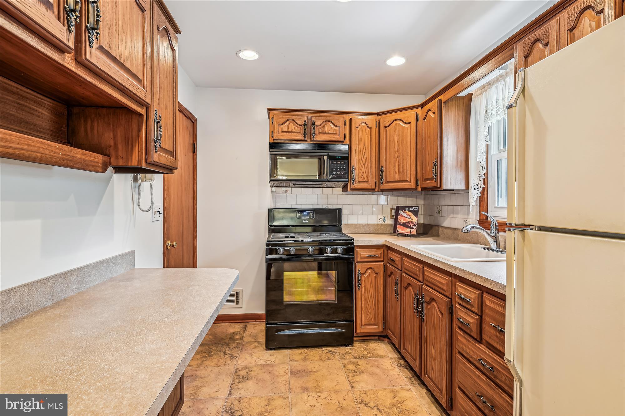 1418 Larch Road Severn, MD 21144 - Photo 14 of 36 a kitchen with stainless steel appliances granite countertop a stove a sink and a refrigerator