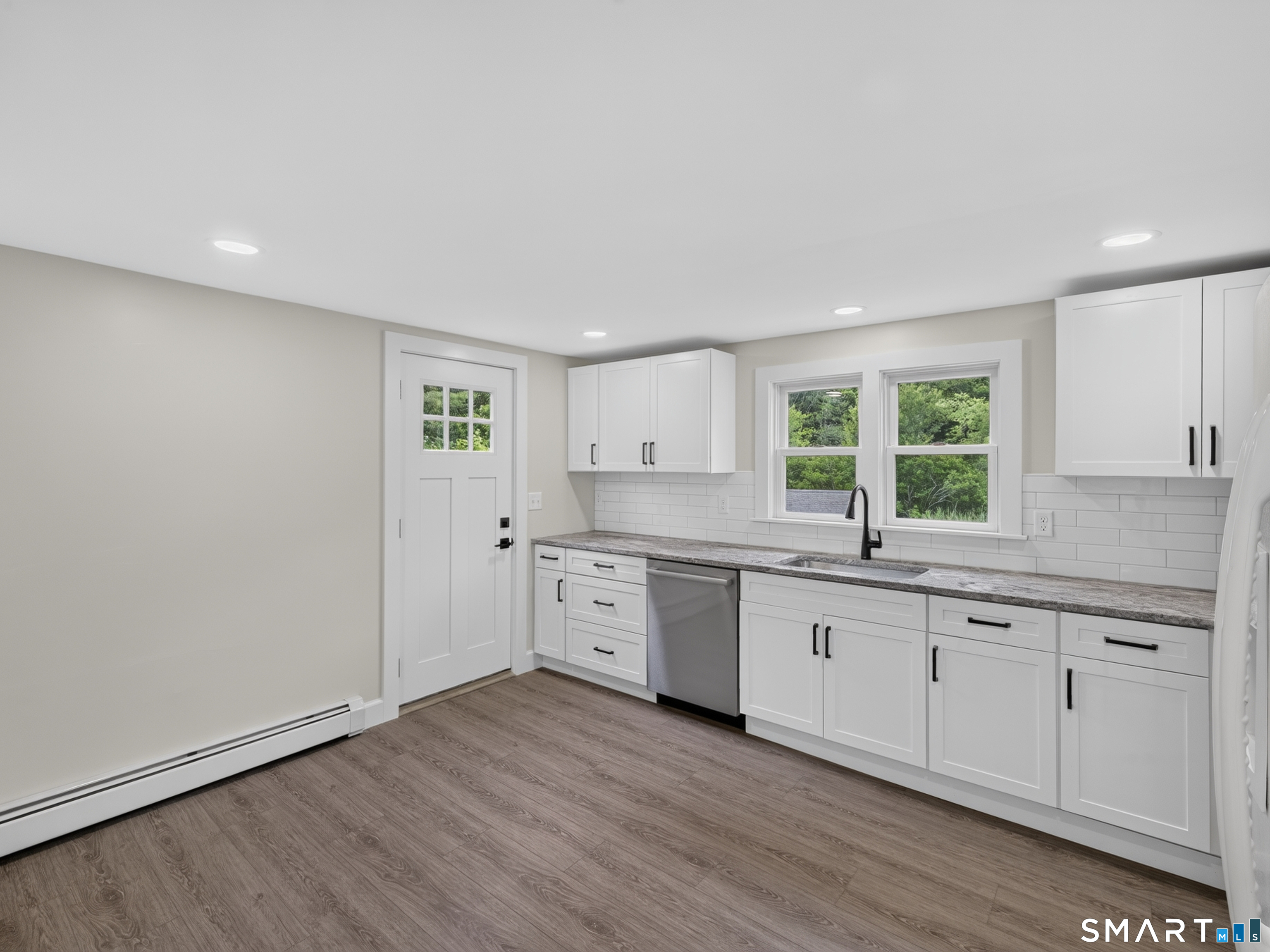 1039 N Road Groton, CT 06340 - Photo 8 of 26 a large kitchen with granite countertop a stove a sink and white cabinets with wooden floor