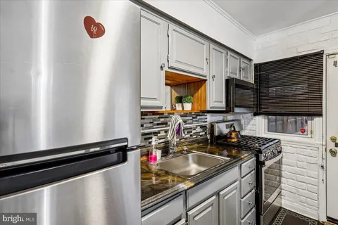 a kitchen with stainless steel appliances granite countertop a sink stove and microwave