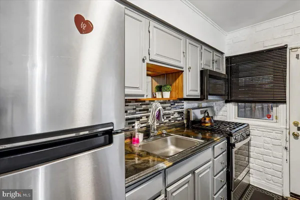 a kitchen with stainless steel appliances granite countertop a sink stove and microwave