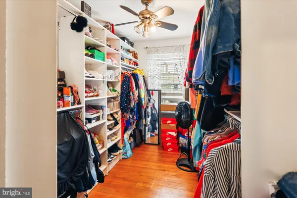 a view of walk in closet with clothes and shoes