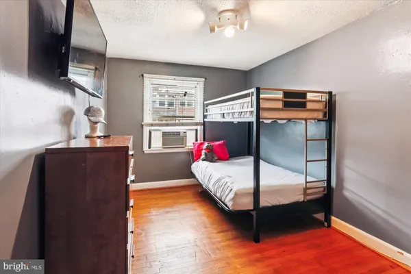 a bedroom with a bed and wooden floor
