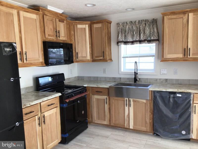 7616 Hunter Drive Morrisville, PA 19067 - Photo 5 of 15 a kitchen with granite countertop a sink a stove and cabinets