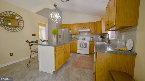 a kitchen with stainless steel appliances granite countertop a sink a stove and a wooden floors