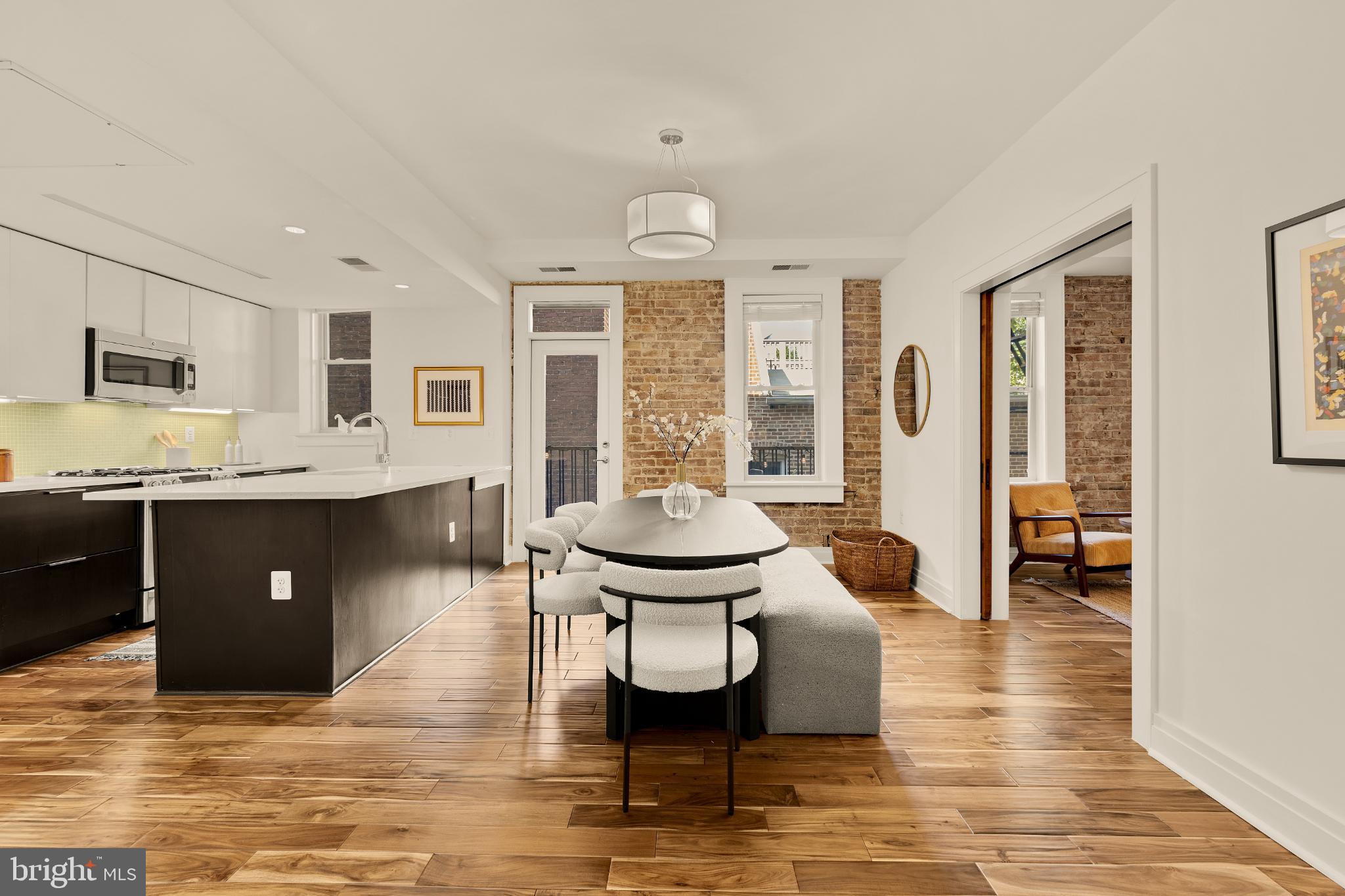 1811 Wyoming Avenue Northwest, Unit 32 Washington, DC 20009 - Photo 13 of 26 a living room with furniture a dining table and kitchen view
