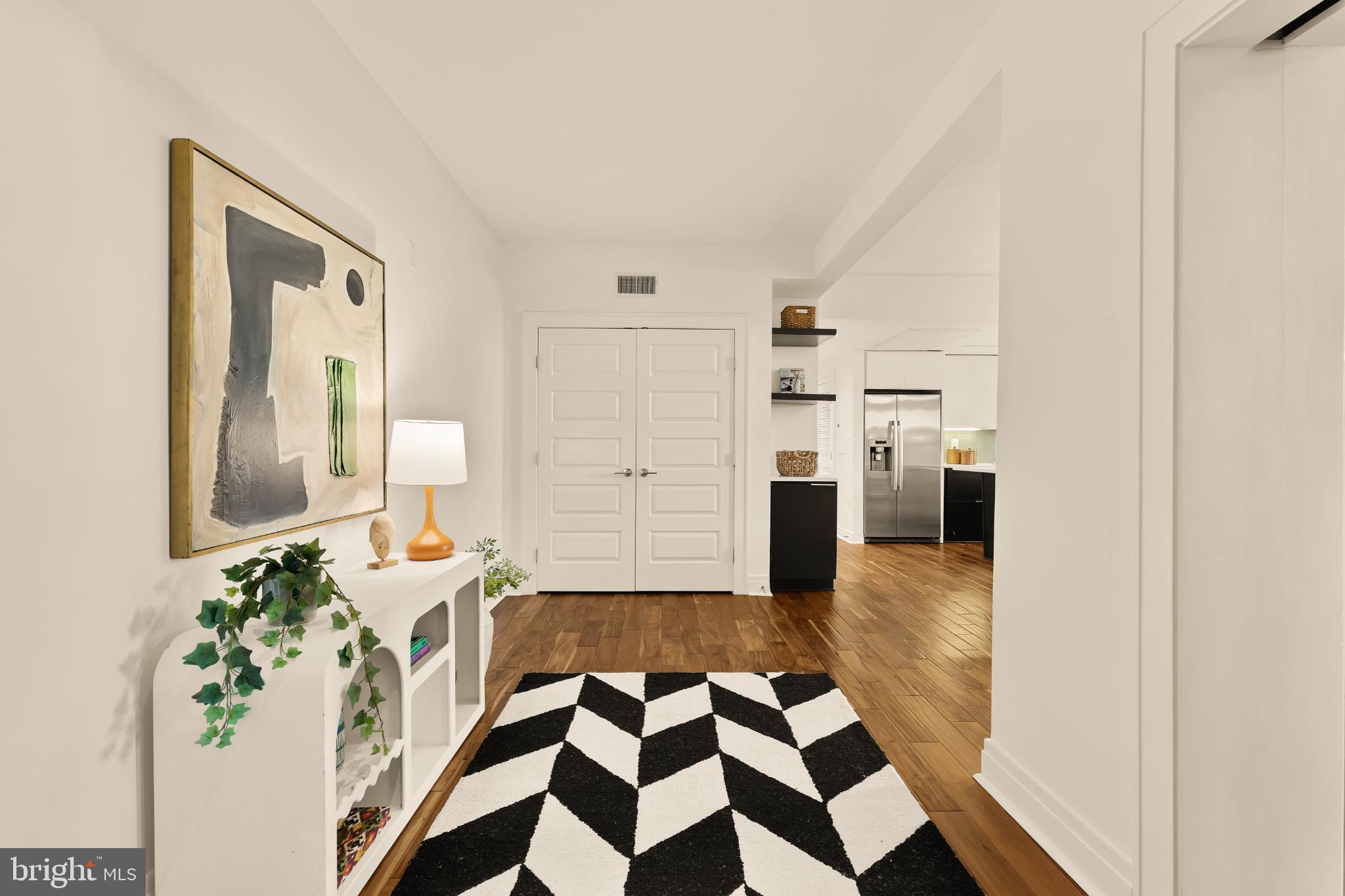 1811 Wyoming Avenue Northwest, Unit 32 Washington, DC 20009 - Photo 4 of 26 a hallway with a black white checkered floor and a white countertops with wooden floor