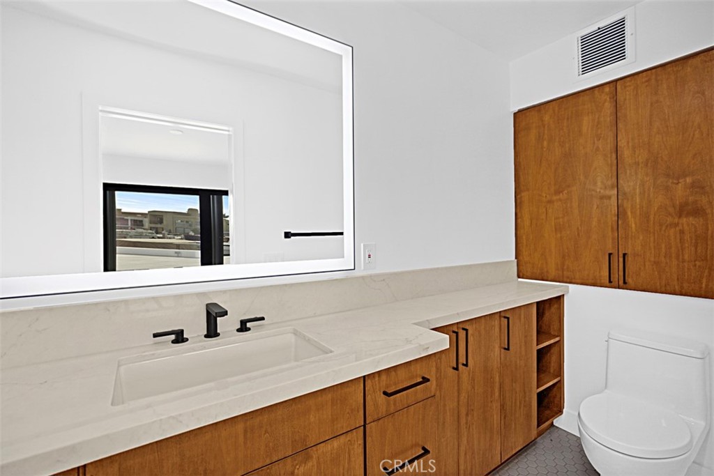 4017 Channel Place, Unit A Newport Beach, CA 92663 - Photo 12 of 18 a bathroom with a sink a toilet and a mirror