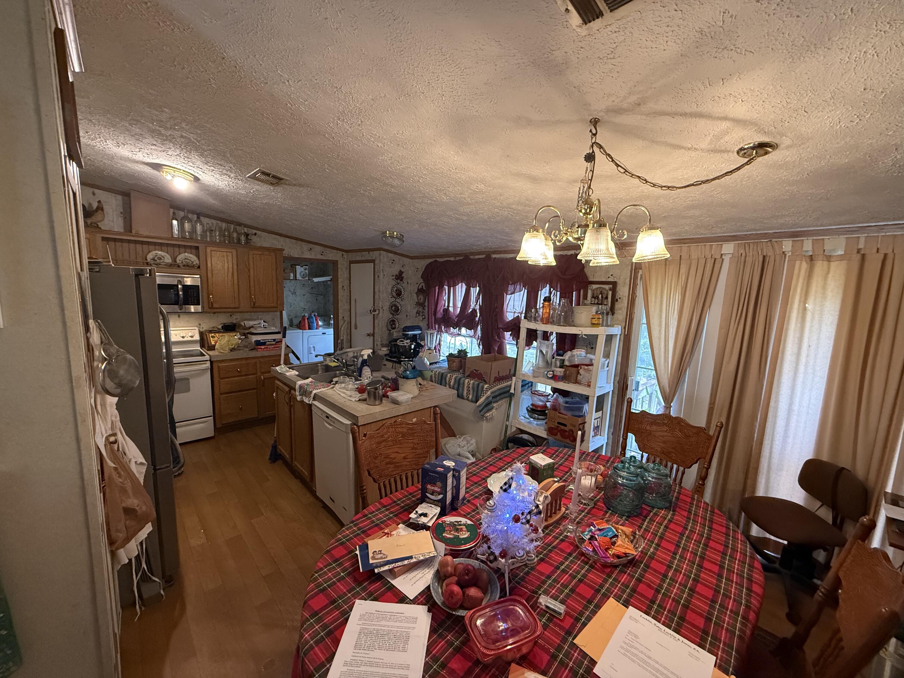 12297 Cooper Road Holt, FL 32564 - Photo 10 of 17 a living room with lots of furniture and a chandelier