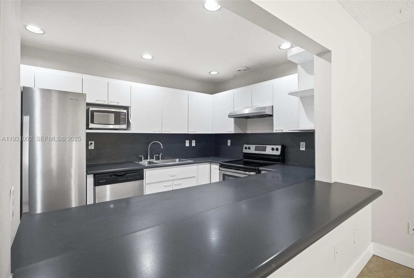 11731 Southwest 112th Terrace Miami, FL 33186 - Photo 15 of 41 a kitchen with granite countertop a refrigerator and a stove top oven