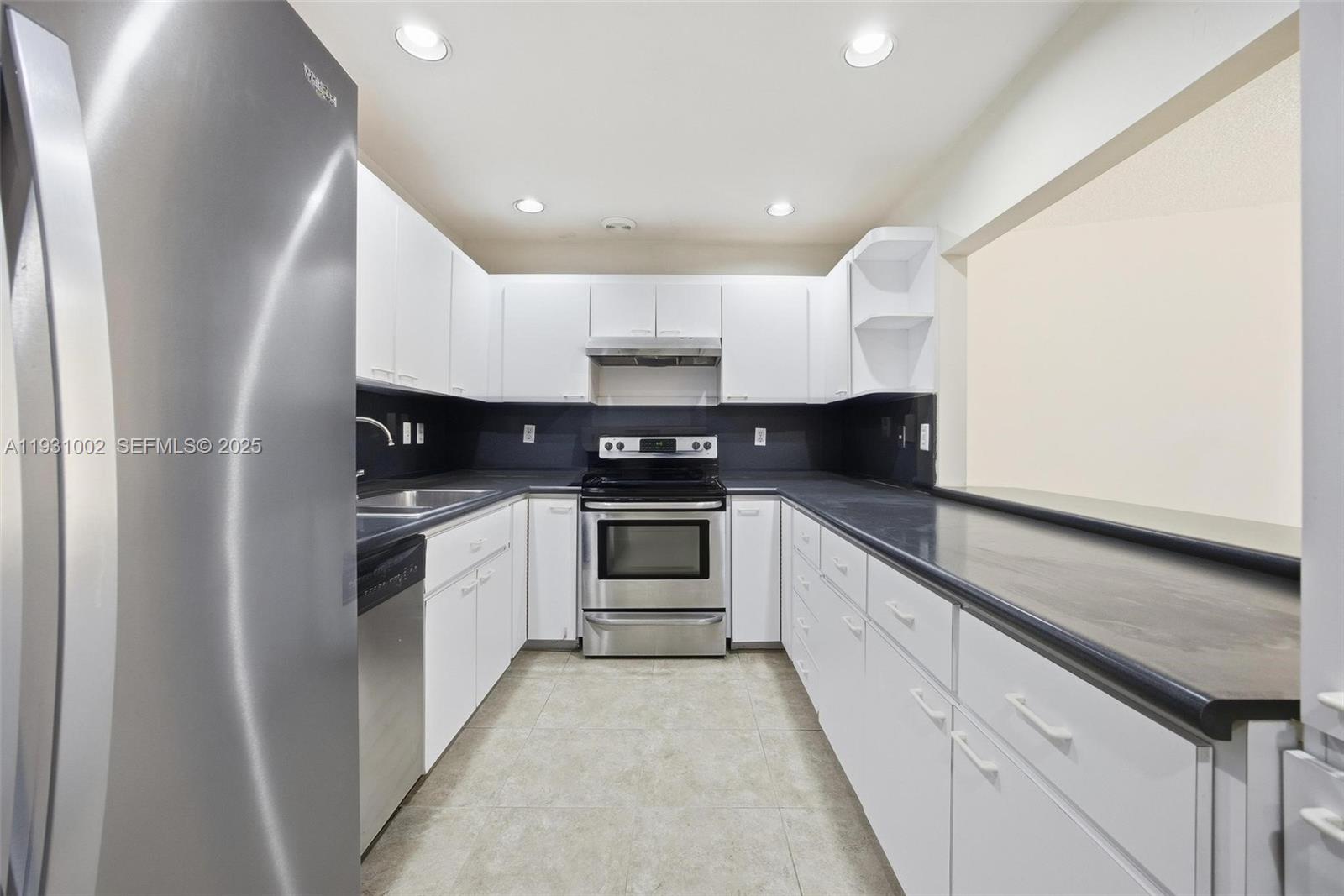 11731 Southwest 112th Terrace Miami, FL 33186 - Photo 18 of 41 a kitchen with granite countertop white cabinets and white appliances
