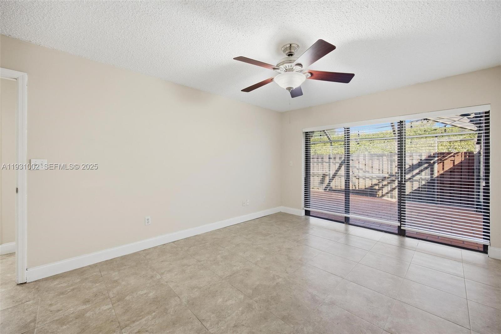 11731 Southwest 112th Terrace Miami, FL 33186 - Photo 28 of 41 an empty room with wooden floor fan and windows