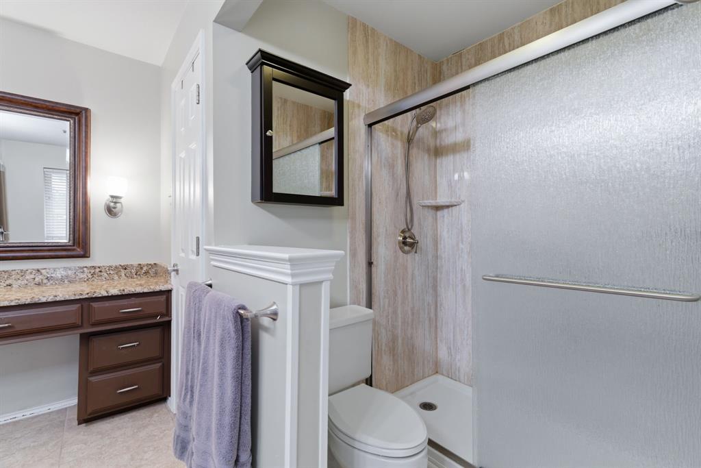 2307 Castle Rock Road Carrollton, TX 75007 - Photo 24 of 34 This bathroom features a shower with textured glass doors and light-toned wall panels
