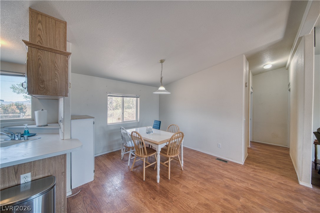 2931 Rio Rancho Drive, Unit 4 Pahrump, NV 89048 - Photo 8 of 21 Warm wood-toned flooring extends through this airy dining space, offering direct kitchen access.