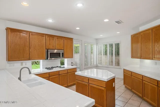 a kitchen with a sink stove top oven and refrigerator