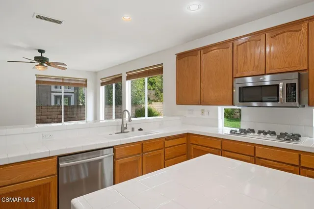 a kitchen with stainless steel appliances granite countertop a sink stove and microwave