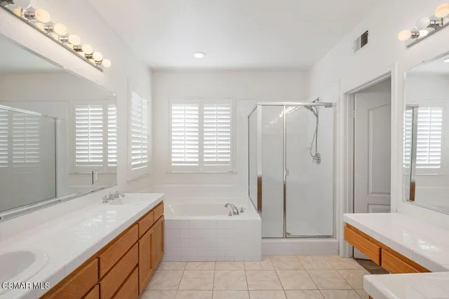 a spacious bathroom with a granite countertop tub sink and mirror