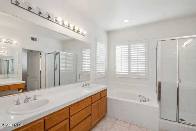 a spacious bathroom with a tub sink and mirror