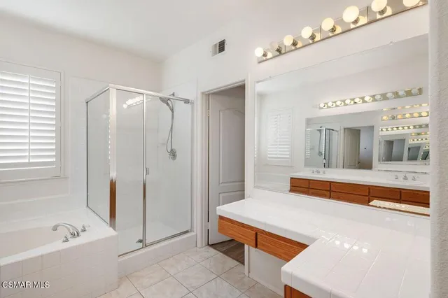 a bathroom with a tub sink and mirror