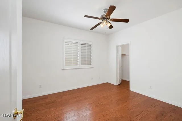 a view of a big room with windows and ceiling fan
