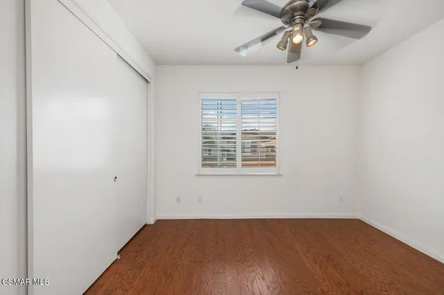an empty room with a window and a fan