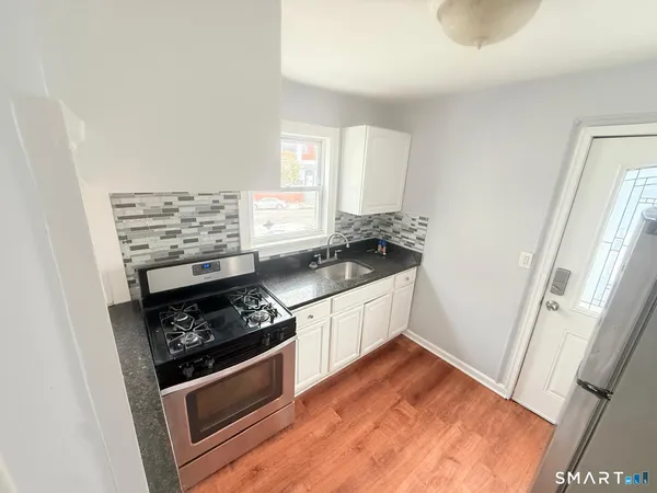 a kitchen with a stove and white cabinets