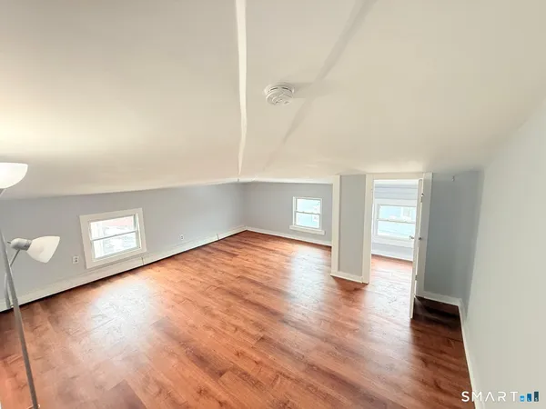 a view of empty room with wooden floor