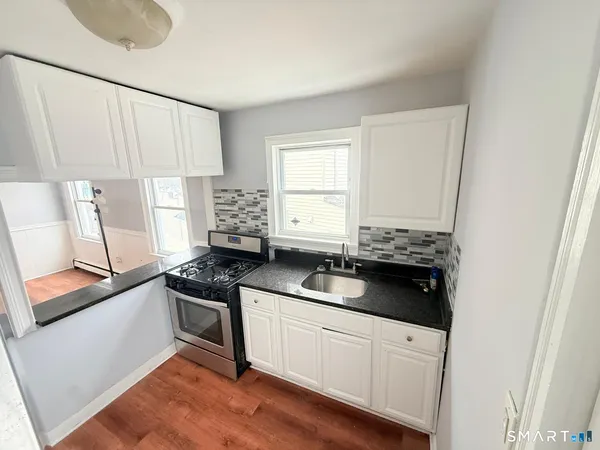 a kitchen with granite countertop a stove and a sink