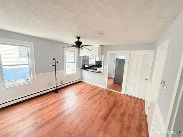a view of a big room with wooden floor and windows