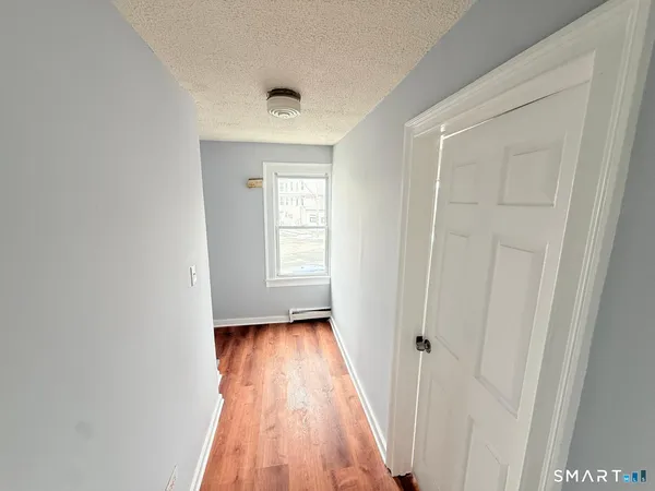 a view of a room with wooden floor and a window