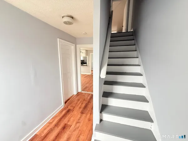 a view of a hallway with wooden floor and entryway