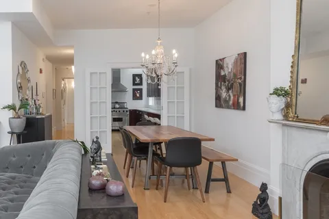 a living room with furniture a chandelier and a dining table