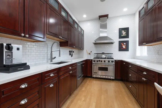 a kitchen with stainless steel appliances granite countertop a stove a sink and a refrigerator