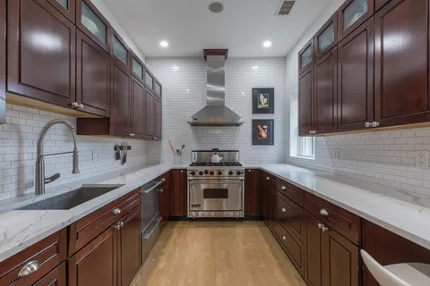 a kitchen with stainless steel appliances granite countertop a sink a stove and cabinets