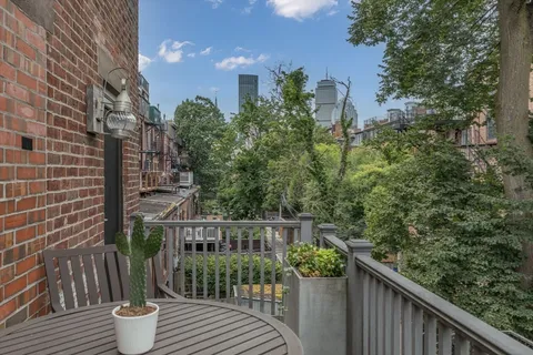 a balcony with wooden floor and outdoor seating