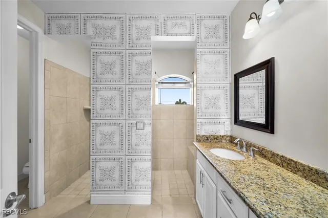 a bathroom with a granite countertop sink a mirror and shower