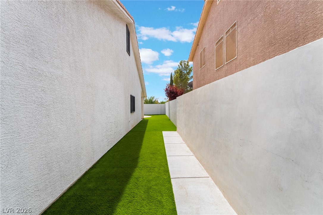 9171 West Viking Road Las Vegas, NV 89147 - Photo 37 of 43 A slender side yard with vibrant artificial turf provides a low-maintenance outdoor corridor.